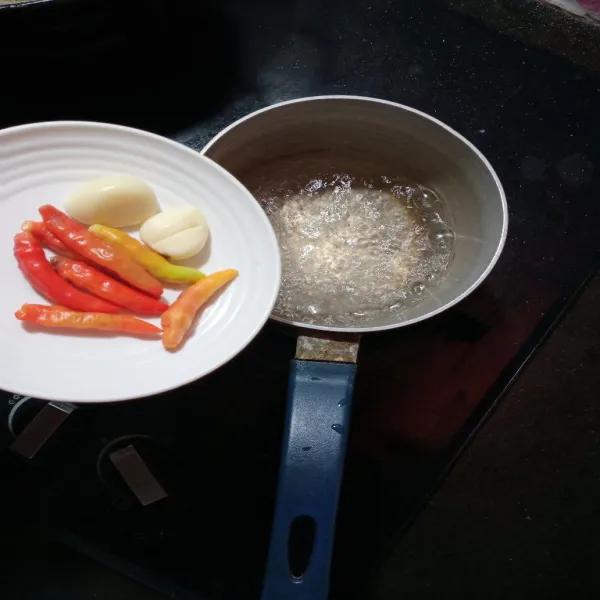 Setelah mendidih, masukan cabe dan bawang putih, masak 2-3 menit.