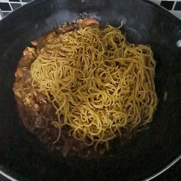 Masukkan mie. Aduk rata dan taburkan daun bawang. Biasa disajikan dengan acar dan kerupuk melinjo.
