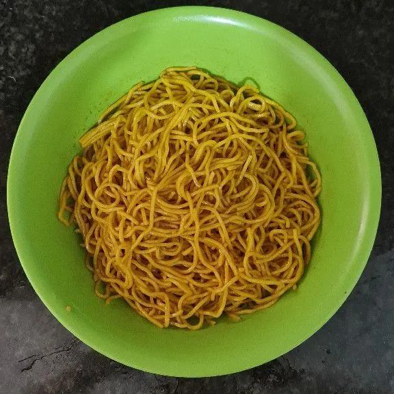 Bumbui mie kuning dengan kecap asin dan kecap manis.