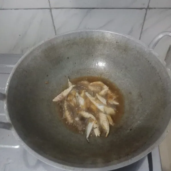 Goreng ikan pindang setengah matang di minyak panas, lalu sisihkan.