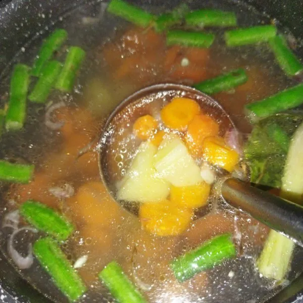 Rebus air hingga mendidih, lalu masukkan wortel, kentang, buncis, dan bumbu yang sudah di tumis. Lalu rebus hingga wortel setengah matang.