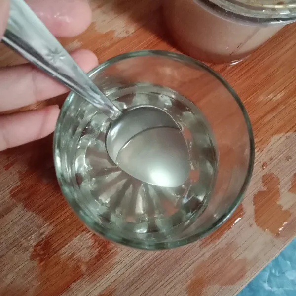 Tuang 80 ml air ke dalam gelas, lalu masukkan madu dan aduk sampai madu larut.