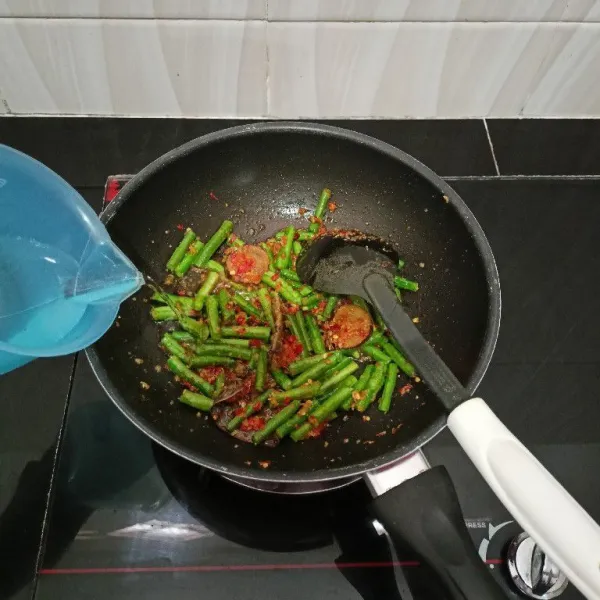 Kemudian masukkan air, gula aren, dan garam. Masak hingga kacang panjang empuk dan air menyusut.