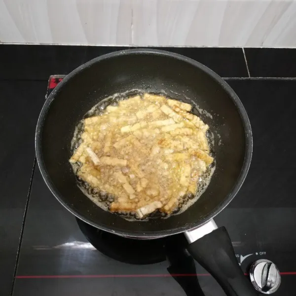 Potong-potong tempe, lalu goreng hingga matang. Angkat dan tiriskan.