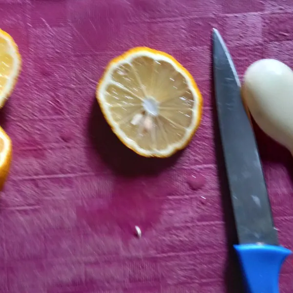 Siapkan buah lemon dan potong melintang satu potongan saja yang dipakai
