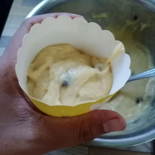 Tuang ke cup muffin 1/2 bagian saja. Taburi dengan choco chip di atasnya.