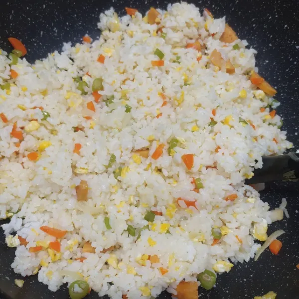 Masukkan nasi putih, bumbui merica bubuk, garam dan kaldu jamur. Aduk rata sambil koreksi rasa sesuai selera.