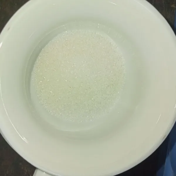 Tuang gula kedalam gelas.