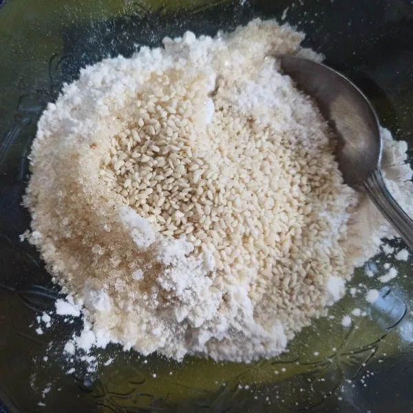 Campur tepung terigu, tepung beras, garam, gula dan wijen jadi satu, aduk rata.