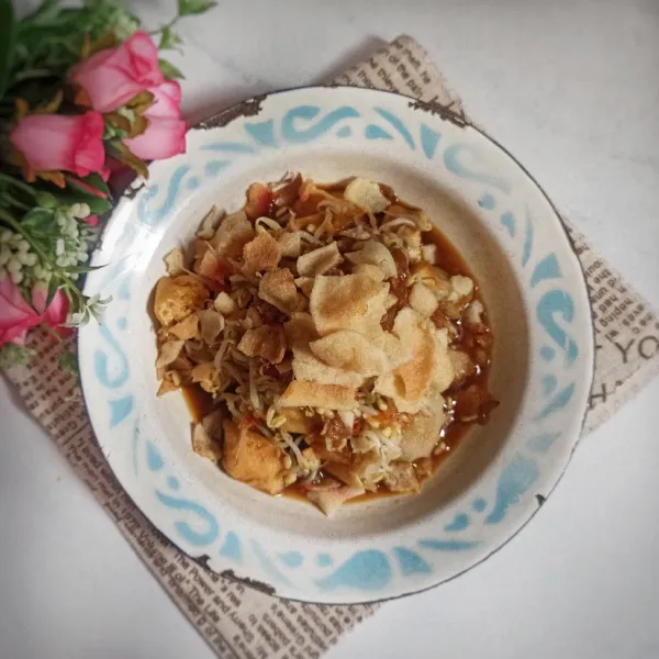 Siapkan piring saji, tata lontong, tahu yang sudah dipotong-potong, dan tauge lalu siram dengan kuah kecap taburi dengan bawang goreng dan kerupuk siap disajikan.