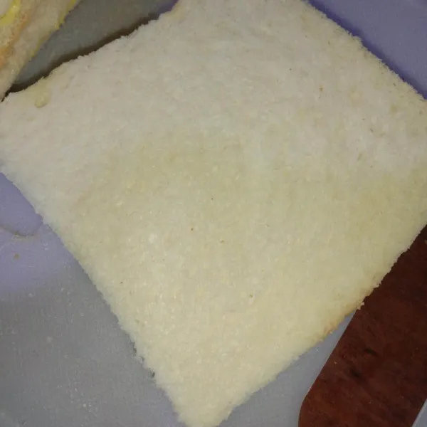 Tumpuk 2 roti tawar, bagian dalam yang ada menteganya.