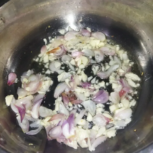 Siapkan panci, lalu panaskan minyak goreng, tumis bawang merah dan bawang putih hingga harum.