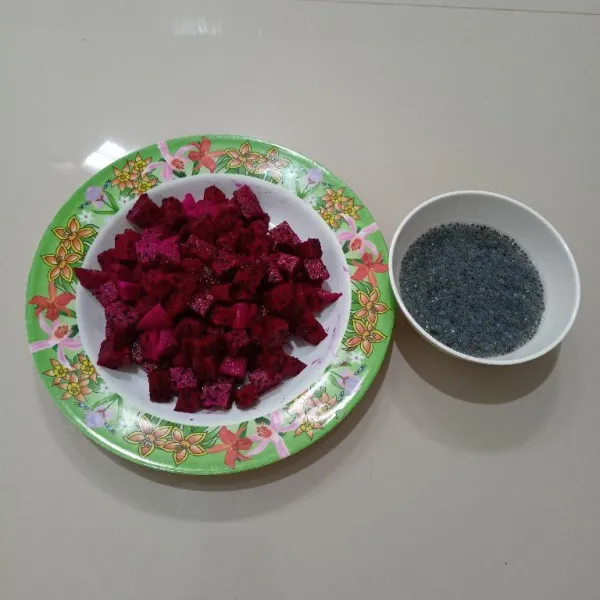 Potong dadu buah naga merah,lalu rendam biji selasih dengan air panas hingga mengembang.