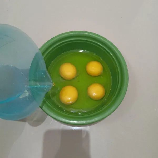 Pecahkan telur dalam mangkok, lalu tambahkan air dan kocok hingga rata.