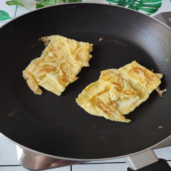 Tuang telur dan garam ke mangkok, aduk dan masak dengan sedikit margarin. Buat petak telurnya lalu bagi 2. Sisihkan.