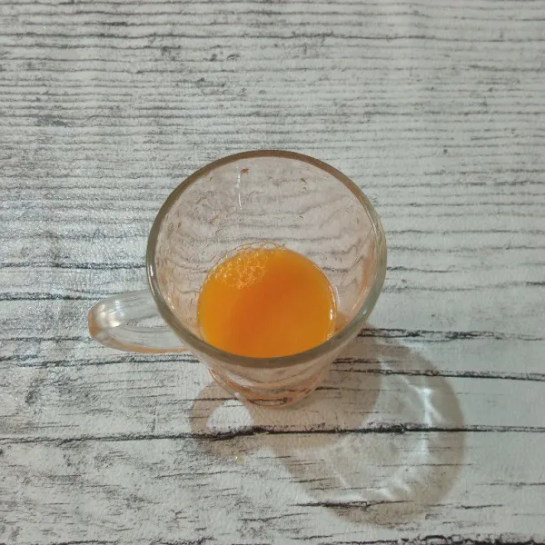 Masukkan air perasan jeruk manis ke dalam gelas saji.