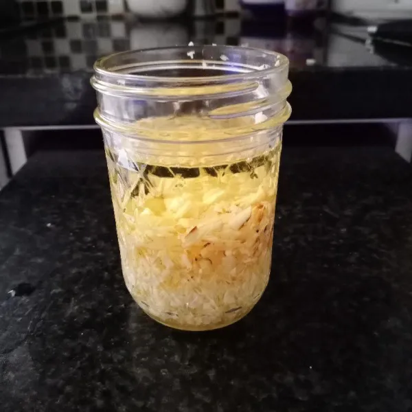 Campurkan bawang putih, kemiri, dan minyak goreng dalam wadah kering.