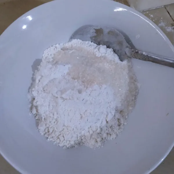 Dalam wadah Masukkan terigu, tepung beras, gula dan garam, aduk rata.
