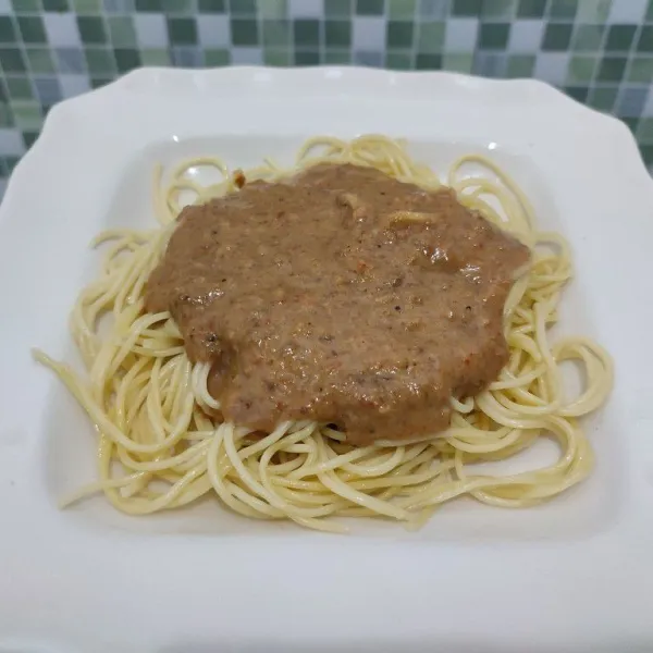 Salin spaghetti ke atas piring saji, kemudian siram dengan kuah pecel, beri kerupuk bawang dan bawang goreng, kemudian sajikan.