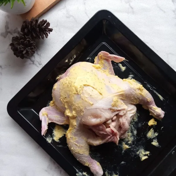 Siapkan ayam. Lap dengan tisu kering. Buka kulit ayam dengan jari tanpa merobeknya. Kemudian beri isian garlic butter. Sisa garlic butter ratakan pada seluruh bagian ayam.