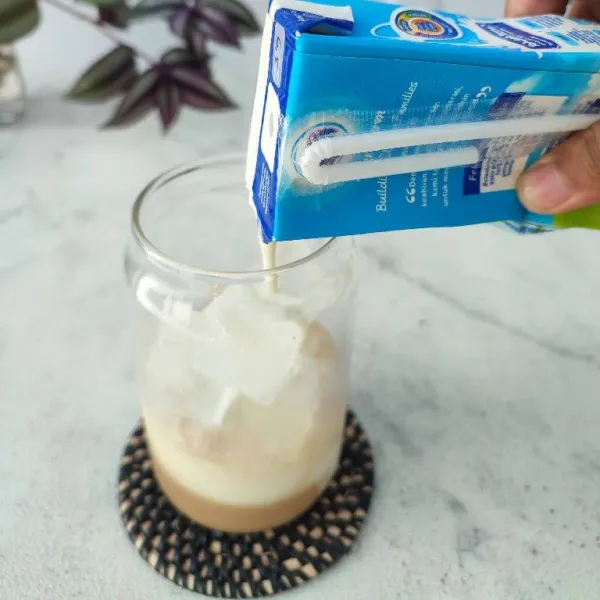 Tambahkan susu full cream sampai ¾ tinggi gelas.