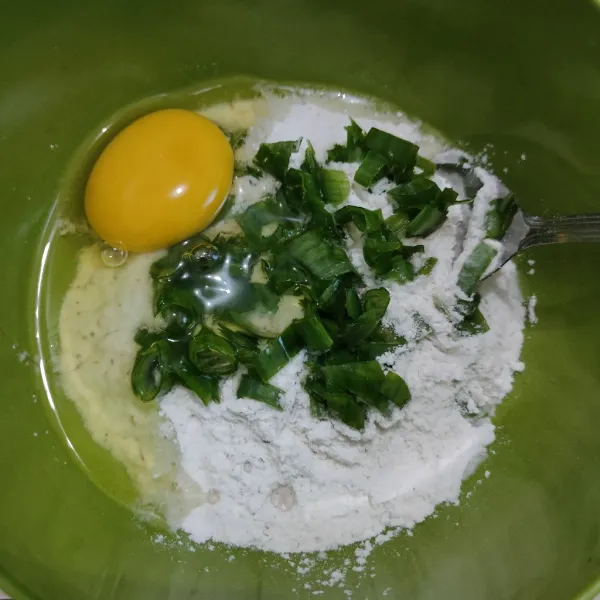 Masukkan tepung serbaguna, telur dan daun bawang ke dalam wadah, aduk rata.