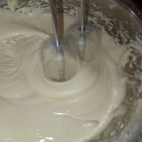 Lalu masukkan tepung, susu bubuk dan garam. Mixer kembali hingga putih berjejak.