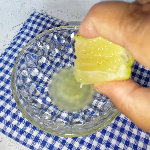 Potong 1/2 buah lemon, peras lemon dan ambil airnya.