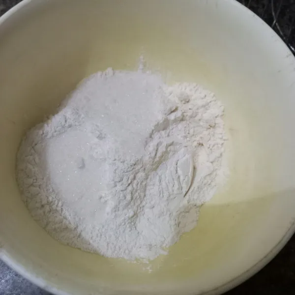 Dalam wadah campur tepung terigu, tepung beras, garam, vanili bubuk dan gula pasir, aduk rata