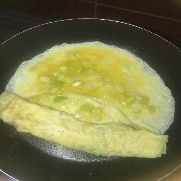 Masukan adonan telur sedikit lalu ratakan, jika sudah setengah masak gulung setengah, lalu masukan lagi adonan sedikit demi sedikit sambil di gulung sampai adonan habis. Masak telur sampai matang.