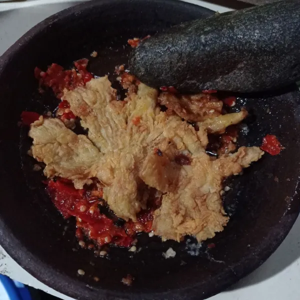 Buat sambal, masukan bahan sambal ke dalam cobek kecuali minyak panas, uleg halus lalu tuang minyak panas, masukan jamur crispy geprek-geprek.
