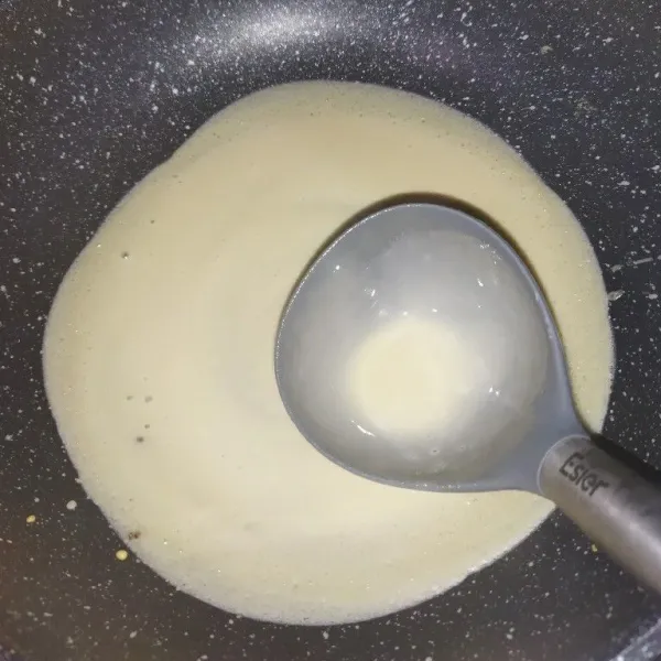 Panaskan wajan, dengan api sedang, jika sudah panas, kecilkan apinya, lalu tuang adonan dengan sendok sayur, kemudian lebarkan adonan dengan sendok sayur.