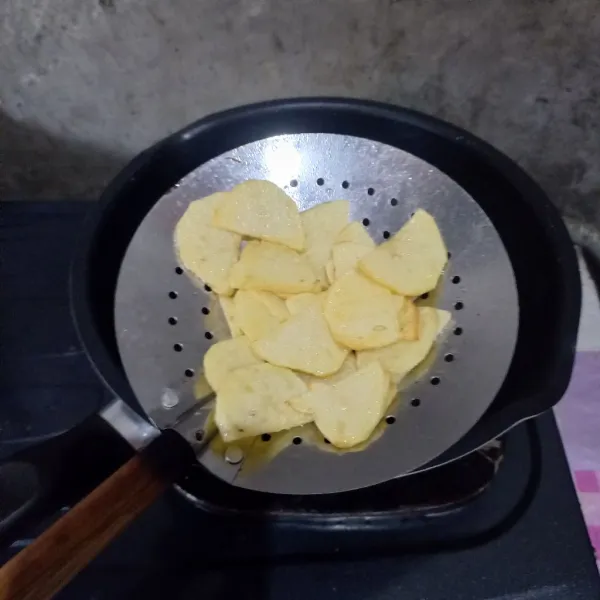 Kupas dan iris kentang. Kemudian goreng sampai matang.