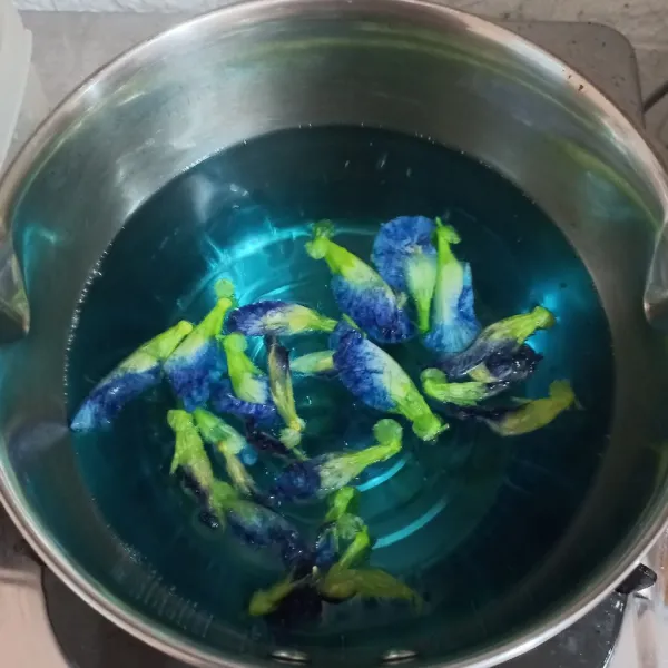 Rebus air dan bunga telang hingga warnanya luntur menjadi biru.