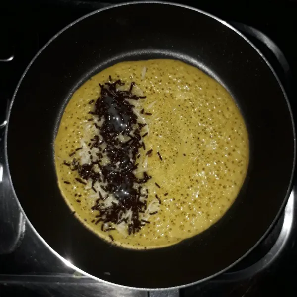 Tambahkan keju parut, meses dan krimer kental manis pada setengah bagian martabak.