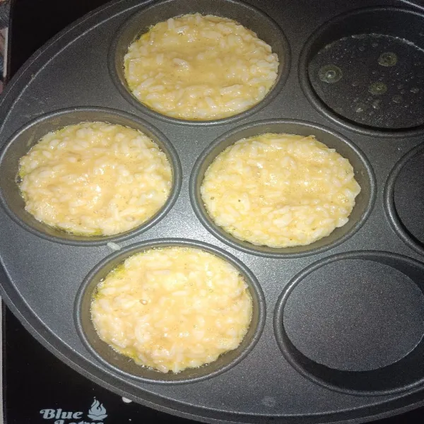 Tuang adonan nasi telur menggunakan sendok sayur.
