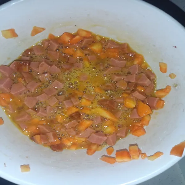 Aduk merata bahan campuran wortel dan sosis.