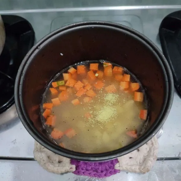 Masukkan kentang, wortel, kaldu bubuk, serta merica, aduk rata.