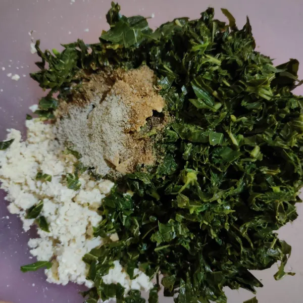 Campurkan tahu, daun singkong, kaldu bubuk, lada bubuk, ketumbar bubuk dan bawang putih bubuk, aduk hingga tercampur rata.