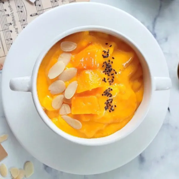 Masukkan smoothies ke dalam gelas lalu tambahkan topping almond slices, mangga, dan selasih. Mango Almond Smoothies siap disajikan.