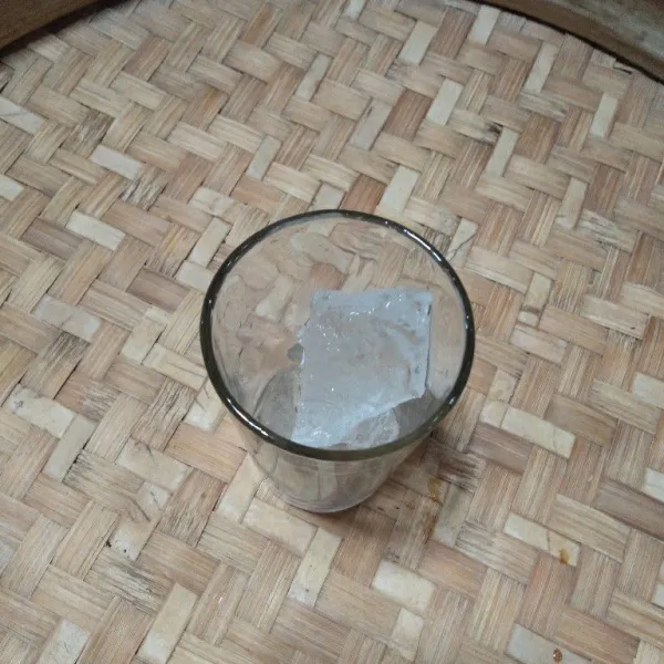Siapkan es batu di dalam gelas saji.
