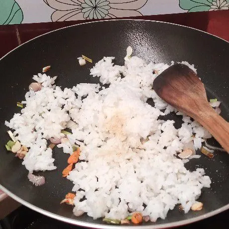 Masukkan nasi, garam, kaldu bubuk. Aduk rata.