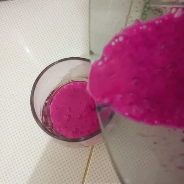 Tuang smoothies buah naga ke dalam gelas.