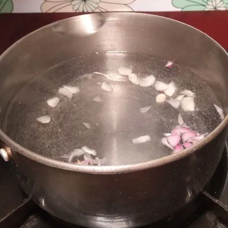 Rebus air bersama irisan bawang merah dan bawang putih.