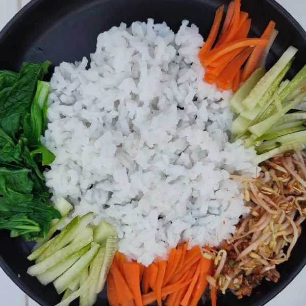 Siapkan nasi putih hangat dalam mangkok atau piring. Kemudian tata sayuran, telur ceplok dan tumisan daging. Taburi dengan wijen sangrai, sajikan selagi hangat.