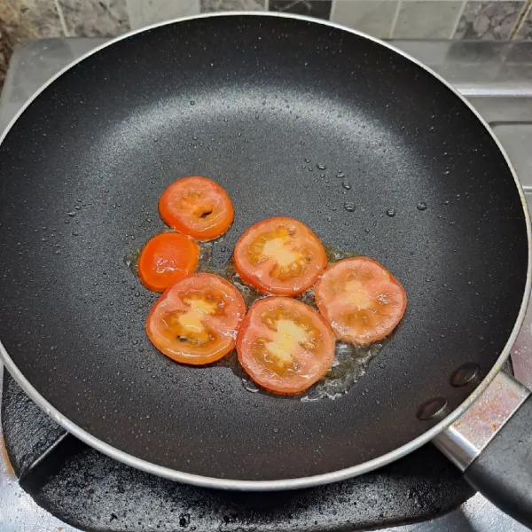 Panaskan teflon dengan sedikit minyak goreng. Tata tomat di teflon. Dengan api kecil agar tidak cepat gosong.