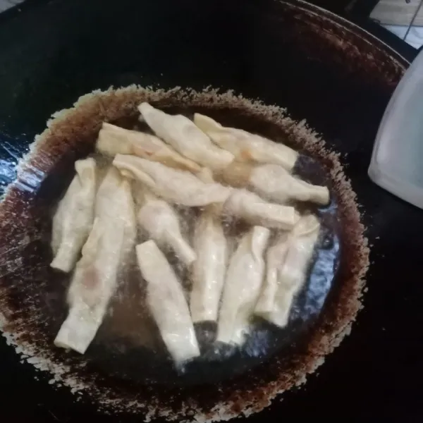 Goreng dalam minyak panas sampai kecoklatan. Gunakan api sedang cenderung kecil agar kulit pangsit tidak gosong.