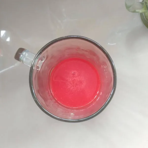 Dalam gelas berbeda, Larutkan bubuk red velvet dengan air. Aduk.