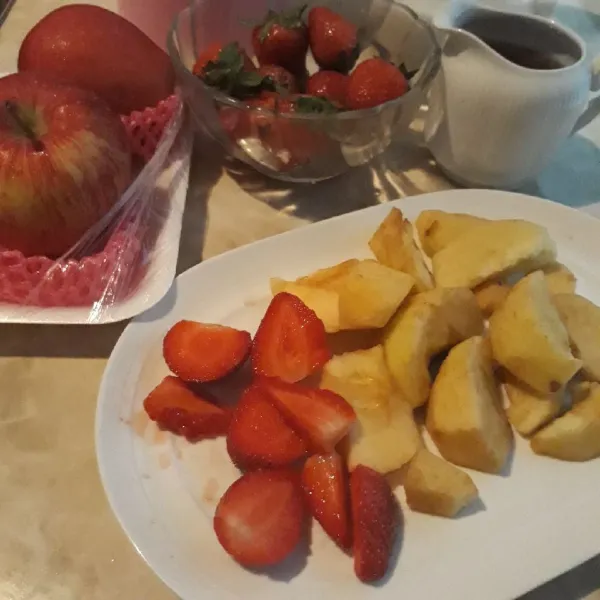 Potong-potong buah apel dan strawberry.