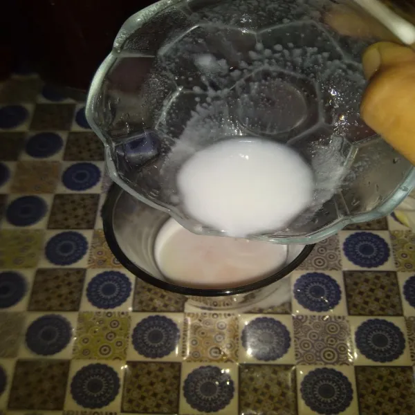 Tuang larutan santan dan susu evaporasi ke dalam gelas.
